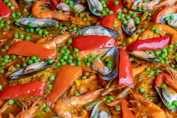 Spanish seafood paella in fry pan with mussels, shrimps and vegetables. Seafood paella background, closeup, traditional spanish rice dish