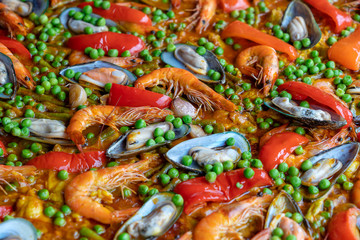 Spanish seafood paella in fry pan with mussels, shrimps and vegetables. Seafood paella background, closeup, traditional spanish rice dish