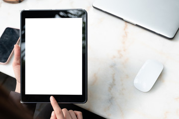 Woman is showing digital tablet  blank screen on work desk in coffee shop.