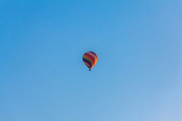 Fototapeta premium Colorful hot air balloon is flying in blue sky 