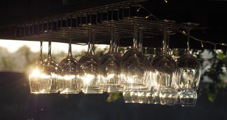 Group of crystal glasses for wine or champagne. Reflections of sun rays in the glass at sunset