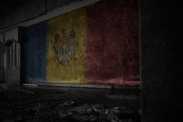 Fototapeta na wymiar painted flag of moldova on the dirty old wall in an abandoned ruined house.