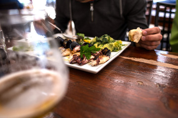 The man eats seafood in the restaurant.