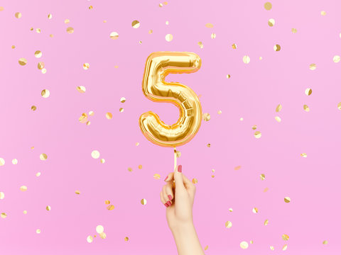 Five year birthday. Female hand holding Number 5 foil balloon.  Five-year anniversary background. 3d rendering