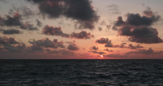 Time lapse of a sunset on the sea level, during partly cloudy sky.