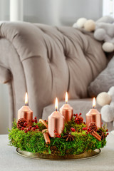 Advent wreath made of moss, cinnamon sticks and rosa canina twigs.