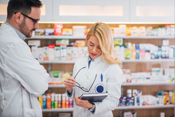 Two pharmacists discussing at work.