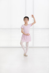 Fototapeta premium Pink dressed Asian girl in a ballet pose..