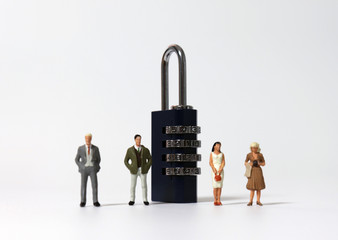 Miniature people standing next to the combination lock.