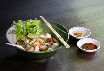 Tom yum noodles in the bowl on brown wooden table