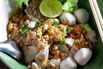 Tom yum noodles in the bowl on brown wooden table