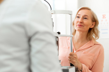 Curious blonde lady attentively listening to conclusions of her doctor