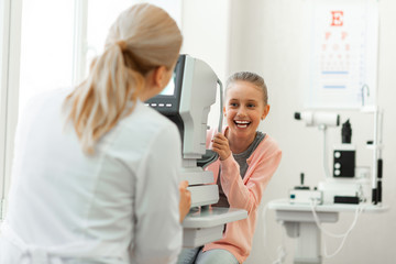 Laughing pretty girl with tied hair having fun while visiting medical cabinet