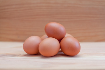 Half a dozen brown eggs on wood