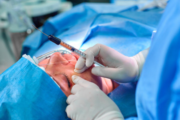 Lipofilling The doctor makes fat injections to the patient in the nasolabial parts of the face.