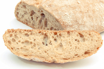 Slice of rye bread and loaf in background