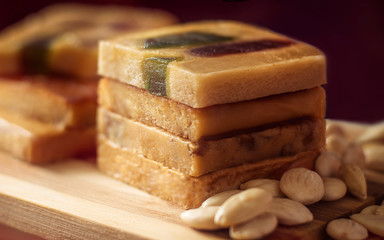 The pyramid of the turron with marmalade on a wooden tray. Selective focus. Blurred background. Traditional Spanish Christmas candy. Nuts.