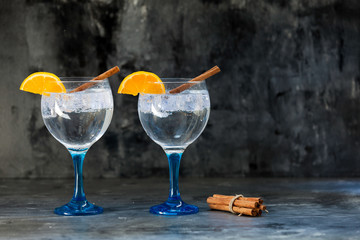 gin tonics on blue glass with cinnamon