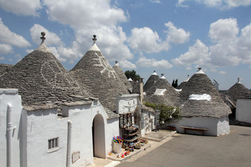 Fototapeta na wymiar Alberobello, Italy - 07.17.2017: Trullas - traditional stone houses with a conical roof, included in the UNESCO World Heritage List