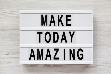 'Make today amazing' words on a modern board on a white wooden background. From above, overhead, flat lay, top view. Closeup.