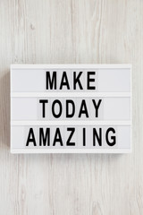 'Make today amazing' words on a modern board on a white wooden surface. From above, overhead, flat lay, top view. Close-up.