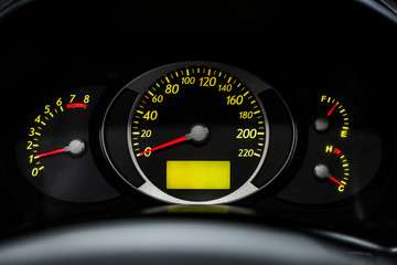 Fototapeta premium Interior view of car with black salon. Modern luxury prestige car interior: speedometer, dashboard and tachometer with yelow backlight and other buttons.