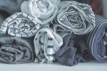 Marie Kondo tyding up method concept - folded clothes. White, gray, blue and striped T-shirts. Selective focus, toned image