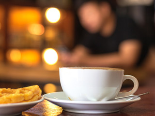 Cup of hot coffee with cake on a rustic wooden table