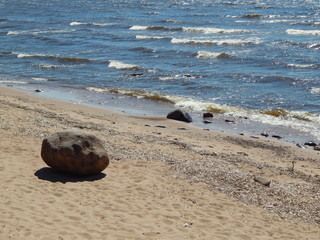 Sandy beach and sea surf on a sunny day