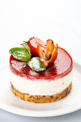 Creamy dessert with strawberry jelly and biscuit. On white background.