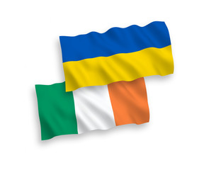 National vector fabric wave flags of Ireland and Ukraine isolated on white background. 1 to 2 proportion.