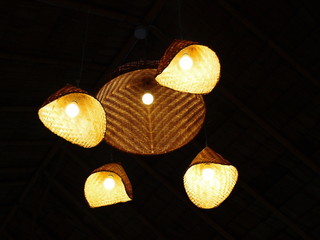 Bamboo lamps are a set of hanging under the roof. Random decoration of traditional bamboo weave On a dark black background.