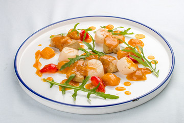 Scallop with strawberries and arugula. On white background