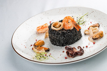 Black rice with seafood. Cuttlefish ink, octopus, mussels, squid and shrimp. On white background
