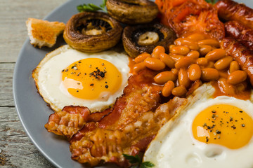 Full English breakfast, with sausage, mushrooms, beans and a fried egg.