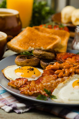 Full English breakfast, with sausage, mushrooms, beans and a fried egg.
