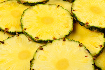 Pineapple juicy yellow slices background. Top view.