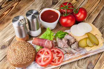 Meat, cheese, tomatoes, onions, cucumbers, lettuce, sauce, spices and bacon. Hamburger ingredients.