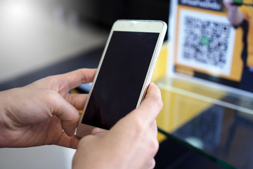 Hands use the phone to scan QR codes to receive discounts on purchases.