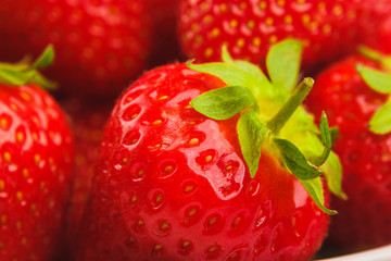 Red ripe strawberry in the white bowl, light background