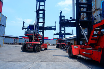 Vehicles that are used to lift three containers, waiting for work in the container yard.