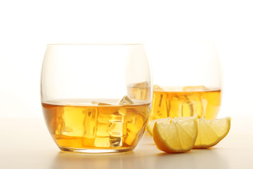 Two glasses with whiskey with ice cubes	