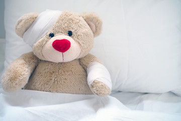 The teddy bear has gauze on the head. Child Injury Concept