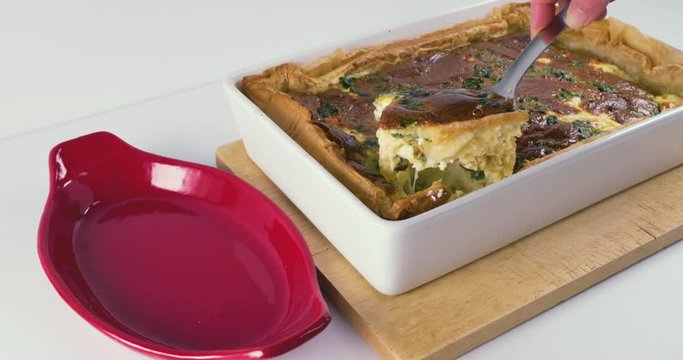 Lady Serving Delicious, Colourful Quiche From A White Tray Into A Red Plate At 60FPS 4K - Spinach, Eggs, Puff Pastry, salt, Cheese, Ricotta, Cheddar.