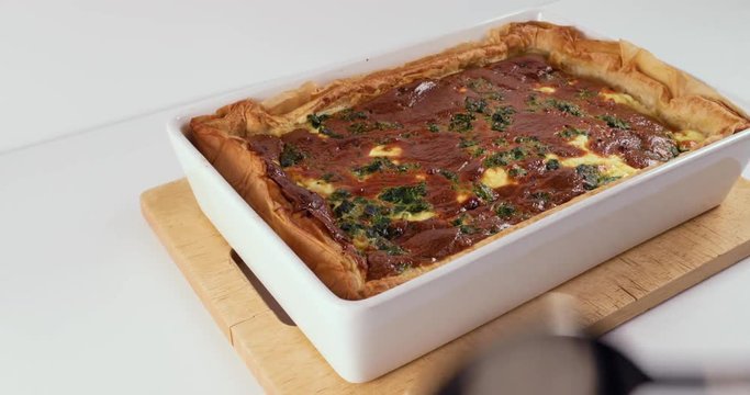 Reverse Time Lapse Of Lady Using Stainless Steel Spoon To Serve A Slice Of Delicious Quiche 60FPS 4K - White Background, White Tray, Spinach, Cheese, Cheddar, Ricotta, Eggs, Baked
