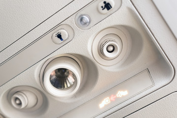 Fasten seat belt light and console panel at the air conditioner above the seat in cabin of low cost commercial airplane .