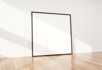 Black frame leaning in bright white interior with wooden floor mockup 3D rendering