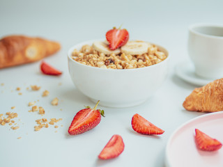 Summer breakfast, croissants with coffee and oatmeal porridge with fruits in a bowl - healthy rustic breakfast