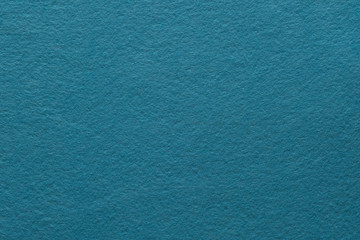 Teal blue felt texture abstract art background. Colored fabric fibers surface. Empty space.