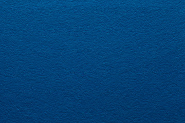 Dark blue felt texture abstract art background. Colored construction paper surface. Empty space.